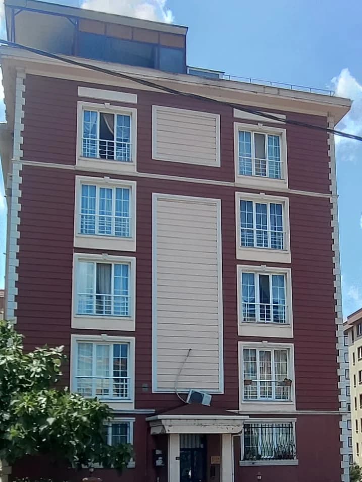 Çatı katı ve üst kat pencereleri; önünden bir elektrik kablosu geçiyor.